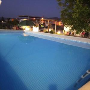 a large blue swimming pool at night at Filuvespri in Comiso