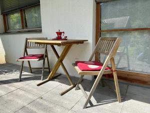 a wooden table and two chairs sitting next to a window at Apartment MEISE in Bad Kleinkirchheim +24 photos