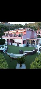 a house with a yard with a hammock in front of it at B&B Villa Fabrizia in Diamante