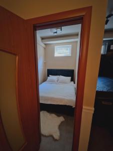 a small bedroom with a bed and a mirror at Mystique Spa Apartment in Belgrade