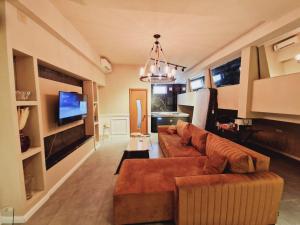 a living room with a brown couch and a tv at Mystique Spa Apartment in Belgrade +18 photos