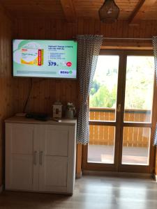a television in a room with a sliding glass door at Chata Soňa in Terchová