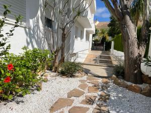 a stone walkway next to a house with a tree at Casa Olé in Jávea