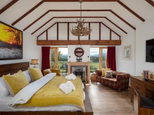 a bedroom with a large bed and a fireplace at The Eagle's Nest in Boat of Garten