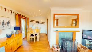 a living room with a fireplace and a dining room at The Shieling in Aviemore