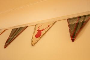 tre cravatte appese a un muro con un cervo sopra. di The Shieling ad Aviemore