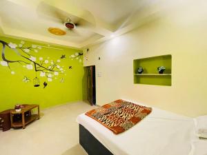 a bedroom with a bed and a green wall at Sun India Guest House in Howrah