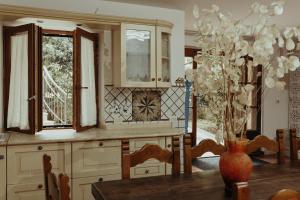 cocina con mesa, ventana y jarrón en La Dolce Vita, en Pitigliano