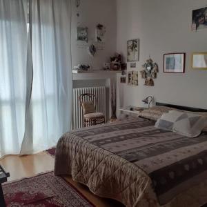 una camera con un grande letto e una sedia di Appartamento casa sul fiume a Parma