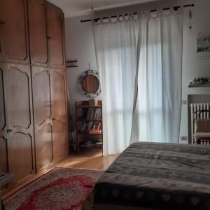 una camera con un letto e una grande finestra di Appartamento casa sul fiume a Parma