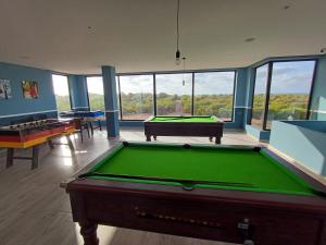 a billiard room with a pool table and some windows at Sidi Rahal Bleu Beach family in Sidi Rahal