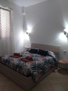 a bedroom with a bed with a comforter on it at Affittacamere da Arianna in Porto Torres