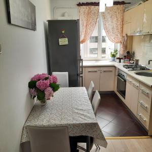 a kitchen with a table and a black refrigerator at Apartament KEPA din Piatra Neamt in Piatra Neamţ