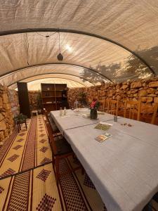 a long table in a room with a stone wall at Barrieh in Rammūn