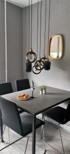 una sala da pranzo con tavolo, sedie e luci di LOCUSDO Apartment No.31 a Mažeikiai