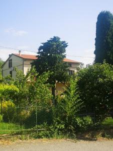 uma cerca em frente a uma casa com árvores em Casa Raffaello em Castiglione dʼOrcia