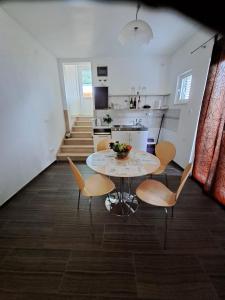 a kitchen and dining room with a table and chairs at Apartmani Dušica in Lumbarda