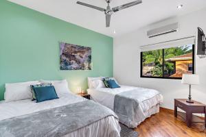 a bedroom with two beds and a window at Casa Mojito~Serene 2 bedroom with prime location! in Tamarindo