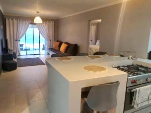 a kitchen and living room with a table and a stove at BLACK ROCK ACCOMMODATION in Hole in the Wall