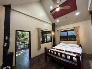 1 dormitorio con 1 cama y ventilador de techo en Dreamer Club Resort Treehouse Suspension Bridge Pool, en Chiang Mai