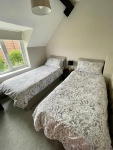1 dormitorio con 2 camas y ventana en Charming just renovated 2 bed cottage in the centre of village en Hartford