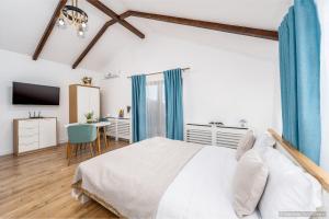 a bedroom with a white bed and a desk at Casa Dora in Suceava