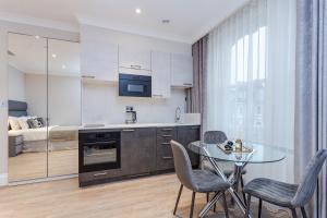 a kitchen with a table and chairs and a bedroom at Cleveland Residences Chelsea in London
