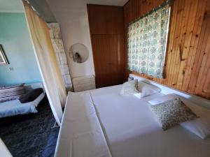 a bedroom with a white bed and a window at Apartmani Dušica in Lumbarda