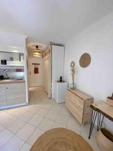 uma cozinha com pisos em azulejo branco e um quarto grande em Studio bohème avec jardinet sans vis à vis em La Croix-Valmer