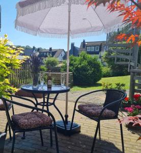 - une table et des chaises sous un parasol sur la terrasse dans l'établissement Hygge Apartment, à Warstein