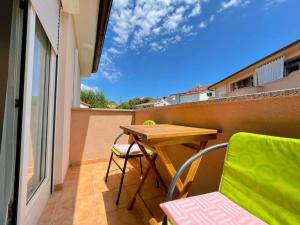 einen kleinen Balkon mit einem Holztisch und Stühlen in der Unterkunft Dolce in Vinkuran