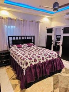 a bedroom with a large bed with a purple comforter at Ifson Home_1 in Kankamsen