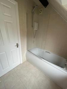 a bathroom with a white tub and a shower at Charming just renovated 2 bed cottage in the centre of village in Hartford