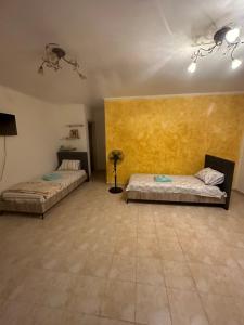 a room with two beds and a yellow wall at Lion Village in Skala Fourkas