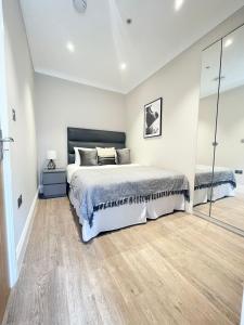 a bedroom with a large bed and a mirror at Cleveland Residences Chelsea in London