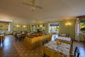 a restaurant with tables and chairs with yellow table cloth at Hotel La Feluca in Portoferraio