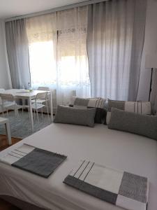 duże białe łóżko w pokoju ze stołem w obiekcie Apartment Ljiljan 2 Niš w Niszu