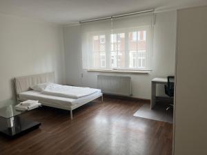 Habitación blanca con cama y ventana en Schönes 3 Zimmer Apartment "Cocco", en Ludwigsburg