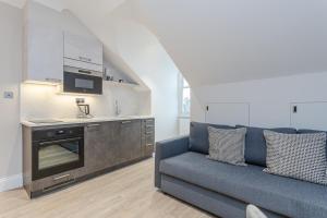 a living room with a couch and a kitchen at Cleveland Residences Chelsea in London