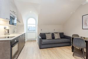 a kitchen and a living room with a couch at Cleveland Residences Chelsea in London