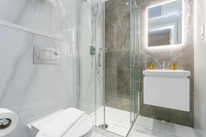 a bathroom with a shower and a toilet and a sink at Cleveland Residences Chelsea in London