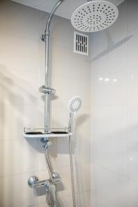een douche met een douchekop in de badkamer bij Przechodnia 2 - Good Apartments in Warschau
