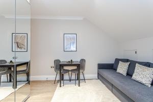 a living room with a blue couch and a table at Cleveland Residences Chelsea in London