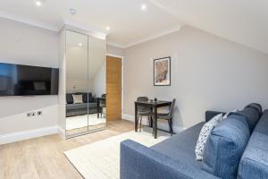 a living room with a blue couch and a table at Cleveland Residences Chelsea in London