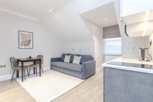 a kitchen and living room with a couch and a table at Cleveland Residences Chelsea in London