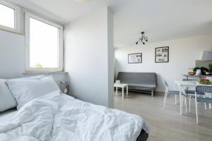 een witte slaapkamer met een bed en een eetkamer bij Przechodnia 2 - Good Apartments in Warschau
