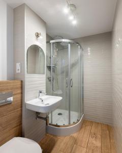 een badkamer met een wastafel en een douche bij Przechodnia 2 - Good Apartments in Warschau