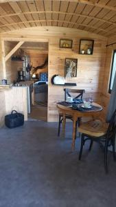 ein Zimmer mit einem Tisch und Stühlen in einer Hütte in der Unterkunft La Bohème in Surville