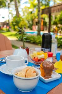 uma mesa azul com pratos de comida e sobremesas em Pousada Fragata - Arraial D Ajuda - Melhor Localização e Atendimento em Arraial d'Ajuda