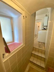 Elle comprend une petite salle de bains pourvue d'une fenêtre et de carrelage. dans l'établissement Petit Martha - gemütlich eingerichtete Wohnung, à Görlitz